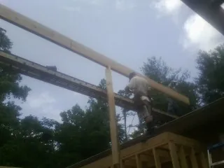 Carpenter setting a ridge beam over a new addition frame — Ice Dam Removal by Roofing Brothers in Calabasas