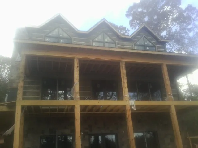 Dormers and porch framing on a large log home under construction — Roof Coating work by our crew in Calabasas