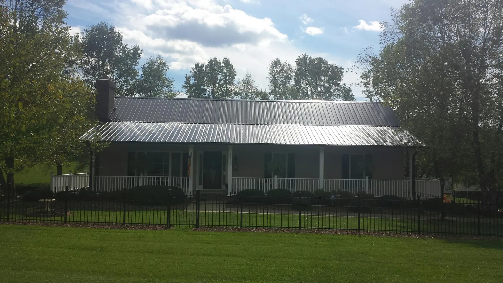 Gray metal roof on a brick ranch with a full width front porch — Gutter Guard Installation work by our crew in Calabasas