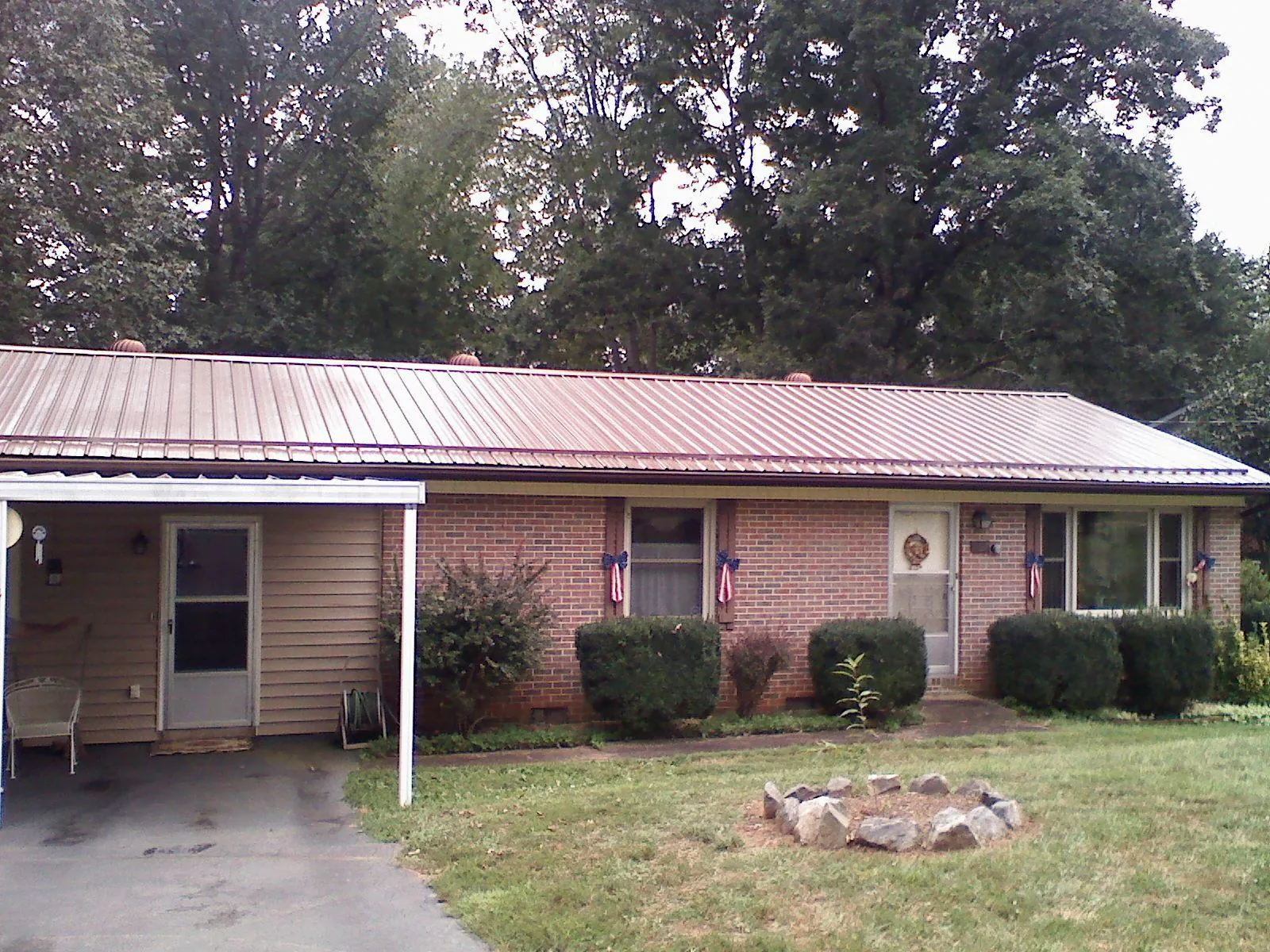 Bronze metal roof and carport on a brick ranch home — Roof Repair work by our crew in Calabasas